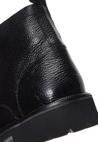 Stivale alla caviglia in pelle nera con finitura texturizzata, forma arrotondata, cuciture rinforzate e suola in gomma spessa per una maggiore durata.