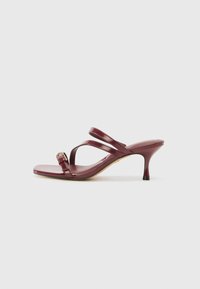 Burgundy lackläder högklackade sandaler med fyrkantig tå, två smala remmar och en dekorativ guldspänne på sidan.