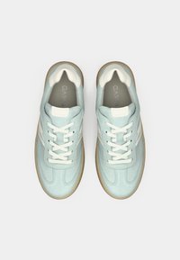 Ζευγάρι από ανοιχτό μπλε σουέτ αθλητικά παπούτσια με λευκά κορδόνια και καουτσούκ σόλες, εμφανιζόμενα από πάνω σε απλό λευκό φόντο.
