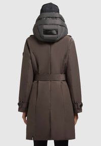 Cappotto isolato marrone con un cappuccio grigio puffato, vita cinte e polsini abbottonati. Presenta un'etichetta con logo sul retro del cappuccio.
