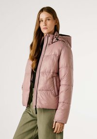 Světlá růžová péřová bunda s kapucí, zipovým uzávěrem a bočními kapsami; má mírně lesklý povrch a prošívaný design.