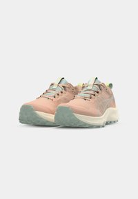 Zapatillas de trail running de color rosa claro con parte superior texturizada, detalles en verde menta y una suela exterior rugosa y translúcida para mayor tracción.