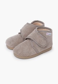 Ciabattine per bambini in morbido beige con texture a coste, cinturino velcro regolabile e fodera imbottita, poggiate su uno sfondo bianco.