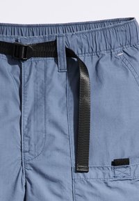 Shorts bleu clair avec ceinture élastique, ceinture noire réglable, tissu texturé et poche latérale avec un accent noir.