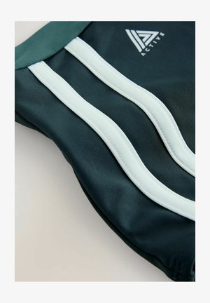 Pantaloni scurți sport de culoare verde închis, cu dungi albastre deschise contrastante și un mic logo. Materialul pare neted, cu un luciu ușor.