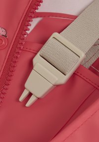 Rosa vattentät ytterlager med dragkedja, kompletterad med en beige spänne och rem, med en texturerad design för säker förankring.