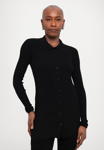 Černý žebrovaný kardigan s dlouhým rukávem a límcem, s knoflíkovým zapínáním a slim fit střih. Texturovaná látka dodává designu hloubku.