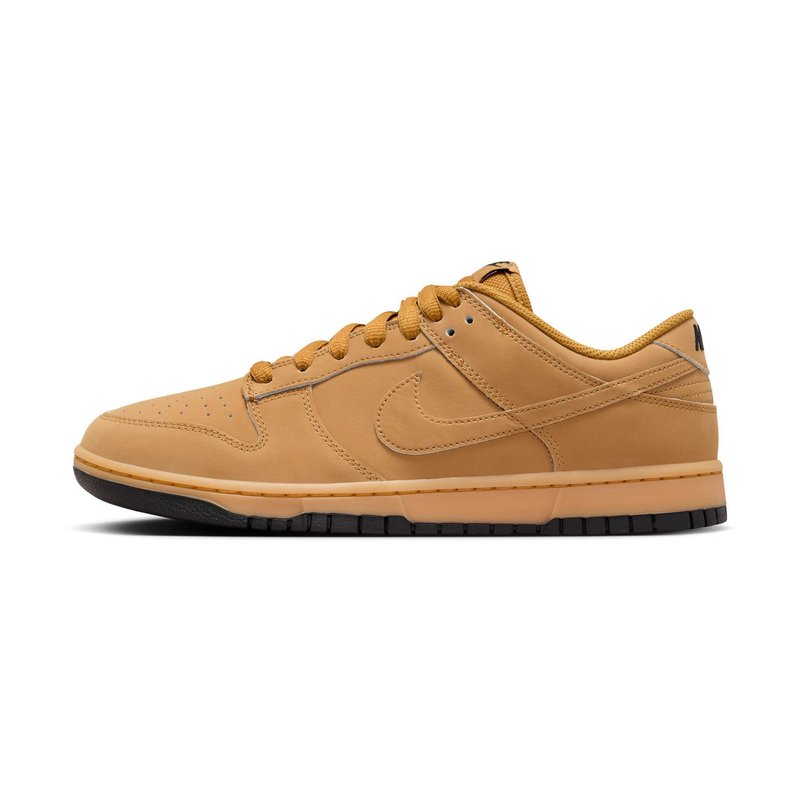 Nike Dunk Low-sneakers i lys tan lær. Funksjoner inkluderer perforert tå, tonale snørebånd og en svart gummisåle.