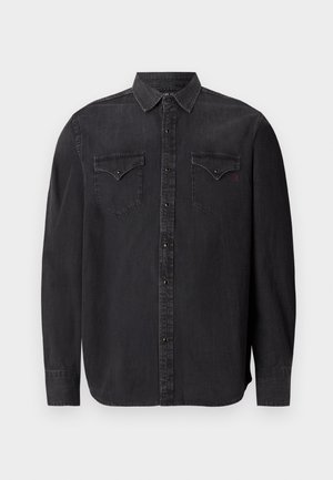 Camicia in denim nera a maniche lunghe con colletto classico, chiusura a pressione, due tasche sul petto e un discreto dettaglio del logo rosso.