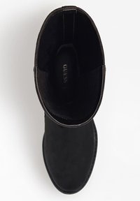 Musta mokkanahka nilkkaboots, jossa on pyöreä kärki, sileä pinta, minimaalinen ommel ja hillitty logo kengän sisäpuolella.