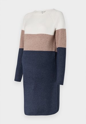 Rochie tricotată cu mâneci lungi, având un design în blocuri de culoare în nuanțe de crem, taupe și bleumarin. Textură moale și gât rotund.