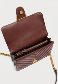 Καφέ δερμάτινη τσάντα ώμου με κεντητό σχέδιο, χρυσά μεταλλικά στοιχεία και αλυσίδα για ιμάντα. Διαθέτει κλείσιμο με καπάκι και εσωτερικό τμήμα με φερμουάρ.