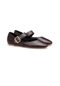 Ein Paar dunkelbraune Leder-Mary-Jane-Ballerinas mit goldenen Schnallenriemen und hellen Sohlen vor einem weißen Hintergrund.