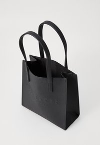 Sac fourre-tout noir en simili cuir texturé, de forme structurée, avec deux poignées robustes et le logo embossé "TED BAKER LONDON" sur le devant.