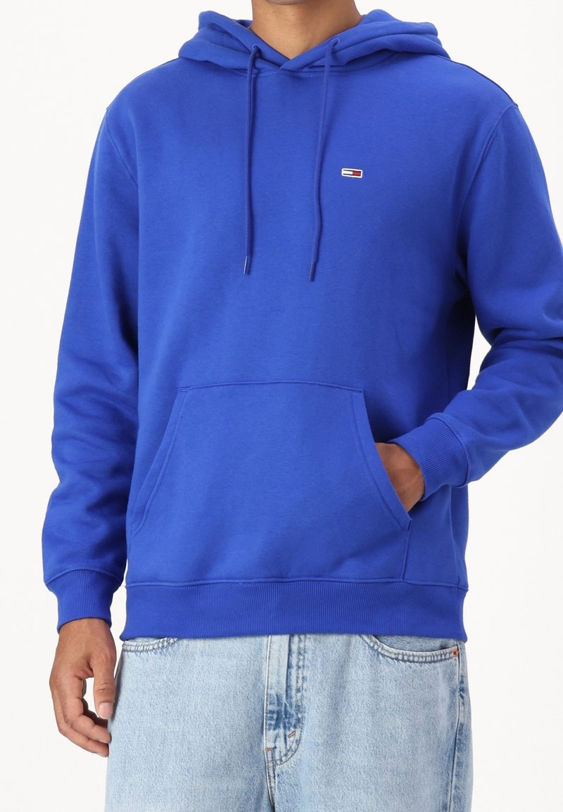 Sweat à capuche en coton bleu avec manches longues, capuche ajustable à cordon de serrage, poche kangourou à l'avant et petit logo sur la poitrine.