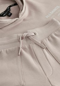 Hellrosa Sweatshirt mit Kapuze, ausgestattet mit einem gerippten Ausschnitt und Bündchen. Enthält einen Kordelzug und vordere Taschen mit weicher Textur.