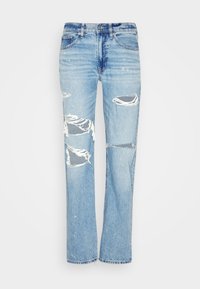 Jeans de mezclilla de corte recto en un azul claro deslavado. Presentan detalles desgastados y bordes deshilachados en las rodillas, además de un clásico diseño de cinco bolsillos.