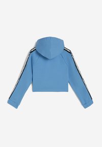 Sudadera azul recortada con capucha, que presenta franjas laterales en blanco y negro. Fabricada con material suave, con puños enrollados y un dobladillo recto.