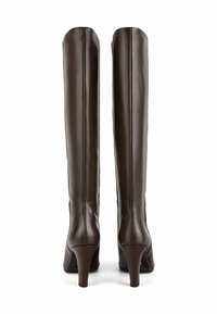 Brązowe skórzane kozaki za kolano na obcasie o smukłym designie, z wysmuklonym noskiem i gładką teksturą. Dodatki obejmują zwężający się obcas.