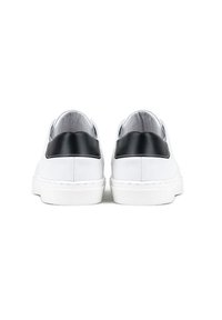 Białe skórzane sneakersy z czarnym syntetycznym detalem na pięcie, płaską białą gumową podeszwą i gładką fakturą, zaprojektowane do codziennego użytku.