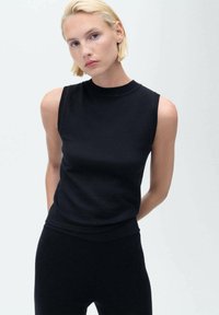 Čierny top bez rukávov vyrobený z pleteného materiálu s vysokým výstrihom, priliehavým strihom a jemnou rebrovanou textúrou. Jednoduchý, minimalistický dizajn.