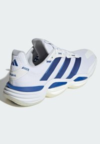 Białe buty sportowe z niebieskimi akcentami, siateczkową cholewką, trzema pasami po bokach, wyściełanym kołnierzem i teksturowaną podeszwą zaprojektowaną dla wsparcia i komfortu.
