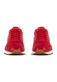 Scarpe sportive in pelle rossa con dettagli bianchi, caratterizzate da una linguetta imbottita, lacci rotondi e una suola esterna in gomma marrone strutturata.