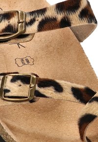 Sandalias con estampado de leopardo que cuentan con dos correas ajustables, hebillas de metal en tono dorado y una plantilla texturizada en color marrón claro con la marca.
