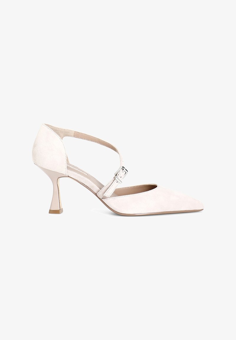 Pointed-toe heel in soft beige suede with a cross strap and silver buckle, featuring a mid-height, clear plastic heel for support.