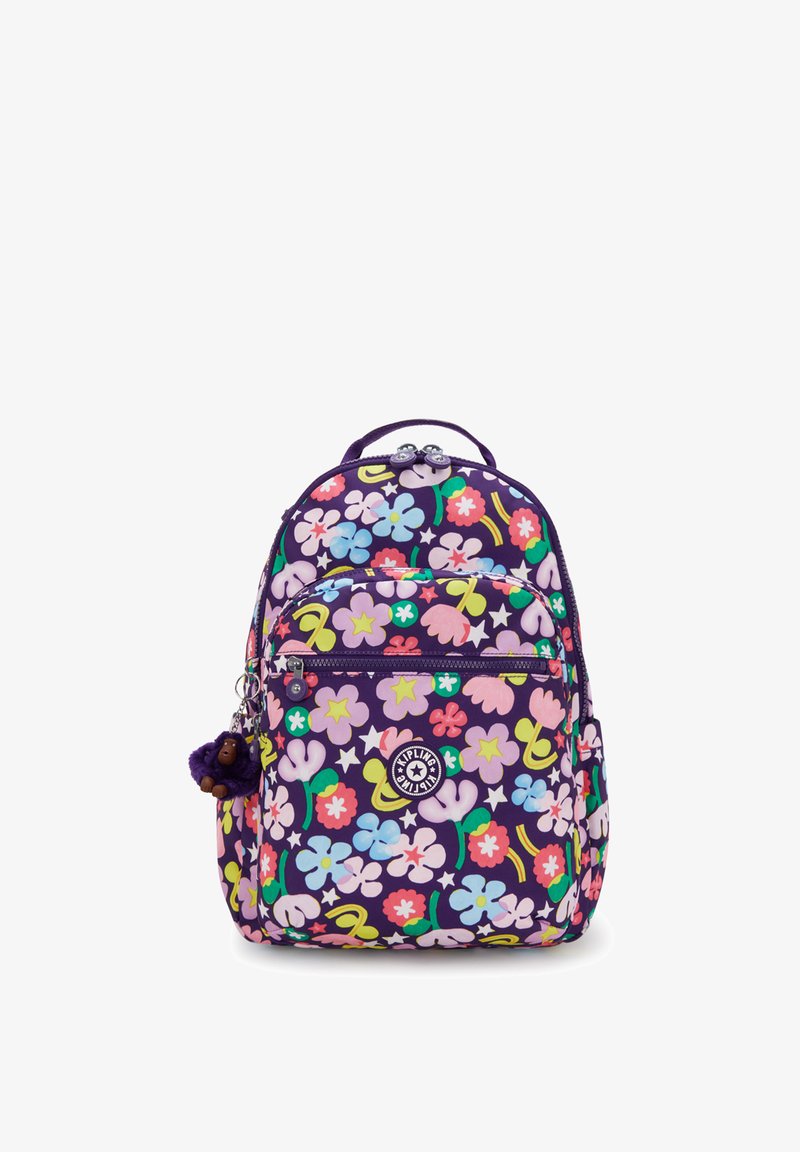 Sac à dos violet avec des motifs floraux multicolores, poche frontale zippée, poches latérales, logo Kipling et un petit porte-clés en forme de singe en peluche attaché.