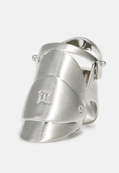 Metallring, der als Ritterhelm gestaltet ist, mit einer gebürsteten Silberoberfläche, geschwungener Form und eingravierten Verzierungen auf der Vorderseite.