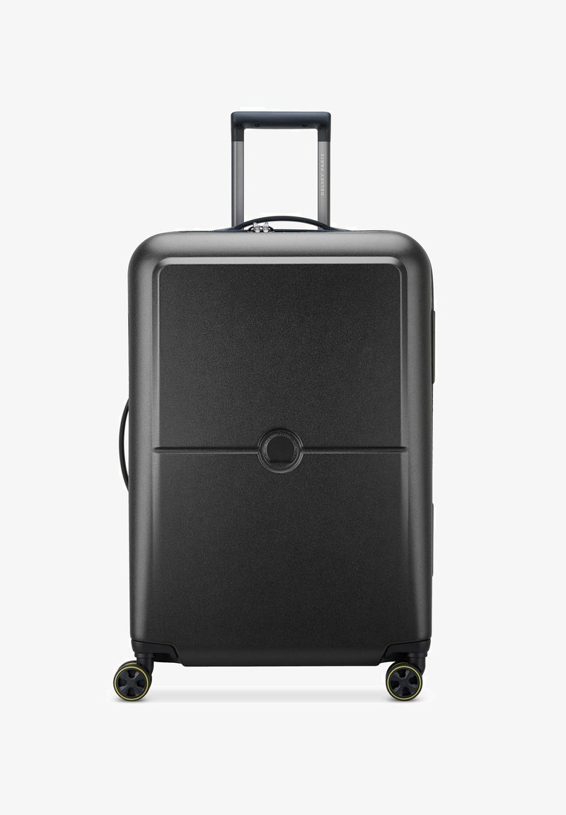 Valigia rigida nera con una texture liscia, manico estensibile e quattro ruote. Dettaglio del logo rotondo centrato sul pannello anteriore.