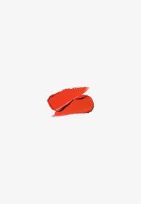 Échantillon de rouge à lèvres rouge vif avec une finition brillante, présentant une texture lisse et une application modulable, sur fond blanc.