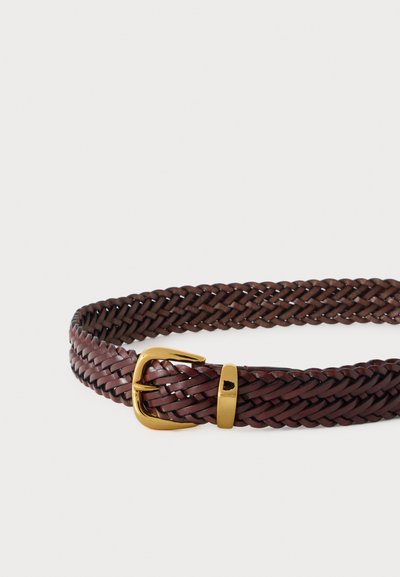 Ceinture en cuir tressé marron foncé avec boucle et passant métalliques dorés brillants, posée à plat sur un fond clair.