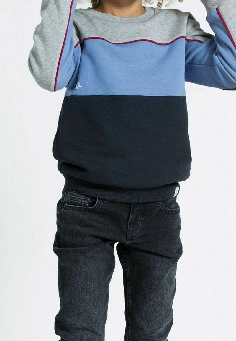 Sweat-shirt rayé bleu marine et bleu clair avec manches grises, col rond et poignets côtelés, assorti à un jean foncé.