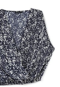 Top senza maniche di colore blu navy con design avvolgente, caratterizzato da una stampa a macchie bianche e un elastico arricciato sull'orlo per una vestibilità aderente.