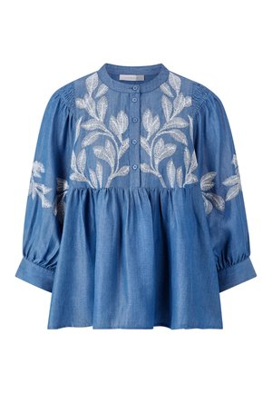 Haut en denim avec un col rond, des boutons sur le devant et de longues manches bouffantes. Caractéristiques de broderies blanches en forme de feuilles sur le corsage et les manches.