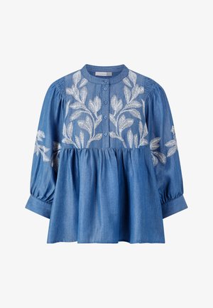 Haut en denim avec un col rond, des boutons sur le devant et de longues manches bouffantes. Caractéristiques de broderies blanches en forme de feuilles sur le corsage et les manches.