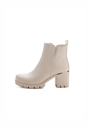 Stivaletti beige in pelle liscia con punta tondeggiante, tacco a blocco e dettagli di cucitura discreti. Presentano un inserto posteriori per l'agevole calzata.