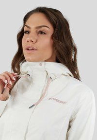 Witte waterdichte jas met een hoge kraag, verstelbare trektouw en een subtiel roze logo op de borst. Glad, strak textuur.