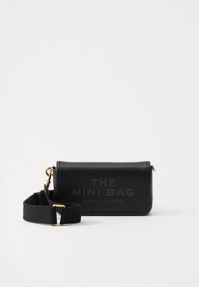 Schwarze Mini-Ledertasche mit eingeprägtem Logo "THE MINI BAG" und "MARC JACOBS." Verfügt über einen abnehmbaren Riemen und goldfarbene Hardware-Akzente.
