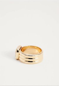 Gouden ring met drie horizontale banden en een rechthoekige, heldere edelsteen bovenop, afgebeeld tegen een witte achtergrond.