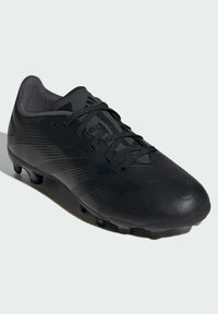 Botas de fútbol negras con parte superior sintética texturizada, con cierre de cordones, perfil bajo y suela con tacos para tracción.