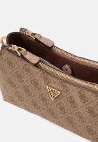 Brązowa monogramowana torebka ze złotym okuciem, z charakterystycznym logo w kształcie trójkąta i dwoma kieszeniami na zamek. Tkanina o fakturze oraz gładka podszewka wewnętrzna.