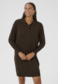 Robe polo marron à manches longues avec col, trois boutons et ourlet côtelé. Texture douce et coupe décontractée, arrivant au milieu des cuisses.