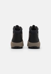Brązowe i czarne buty trekkingowe z wysokim cholewką, wykonane z teksturowanej tkaniny i gumy, z solidną podeszwą i akcentami w postaci logo.