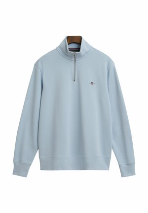 Felpa blu chiaro con zip e colletto alto, realizzata in tessuto morbido, con polsini e orlo a costine, caratterizzata da un piccolo logo sul petto.