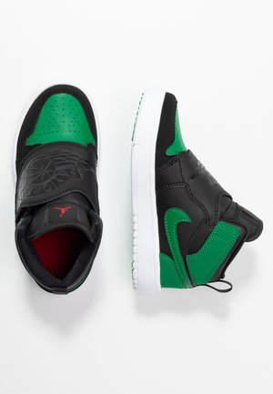 High-top sneakers in black leather with green accents, featuring a perforated toe, strap closure, red logo, and white rubber sole.