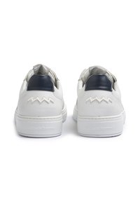 Sneakers bianchi in pelle con tacco blu navy e motivo a zigzag sul retro. Presentano un rivestimento interno testurizzato e una suola marchiata.