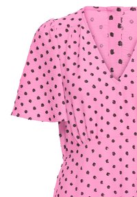 Robe rose à pois noirs irréguliers, manches courtes bouffantes, encolure en V et couture de taille froncée.